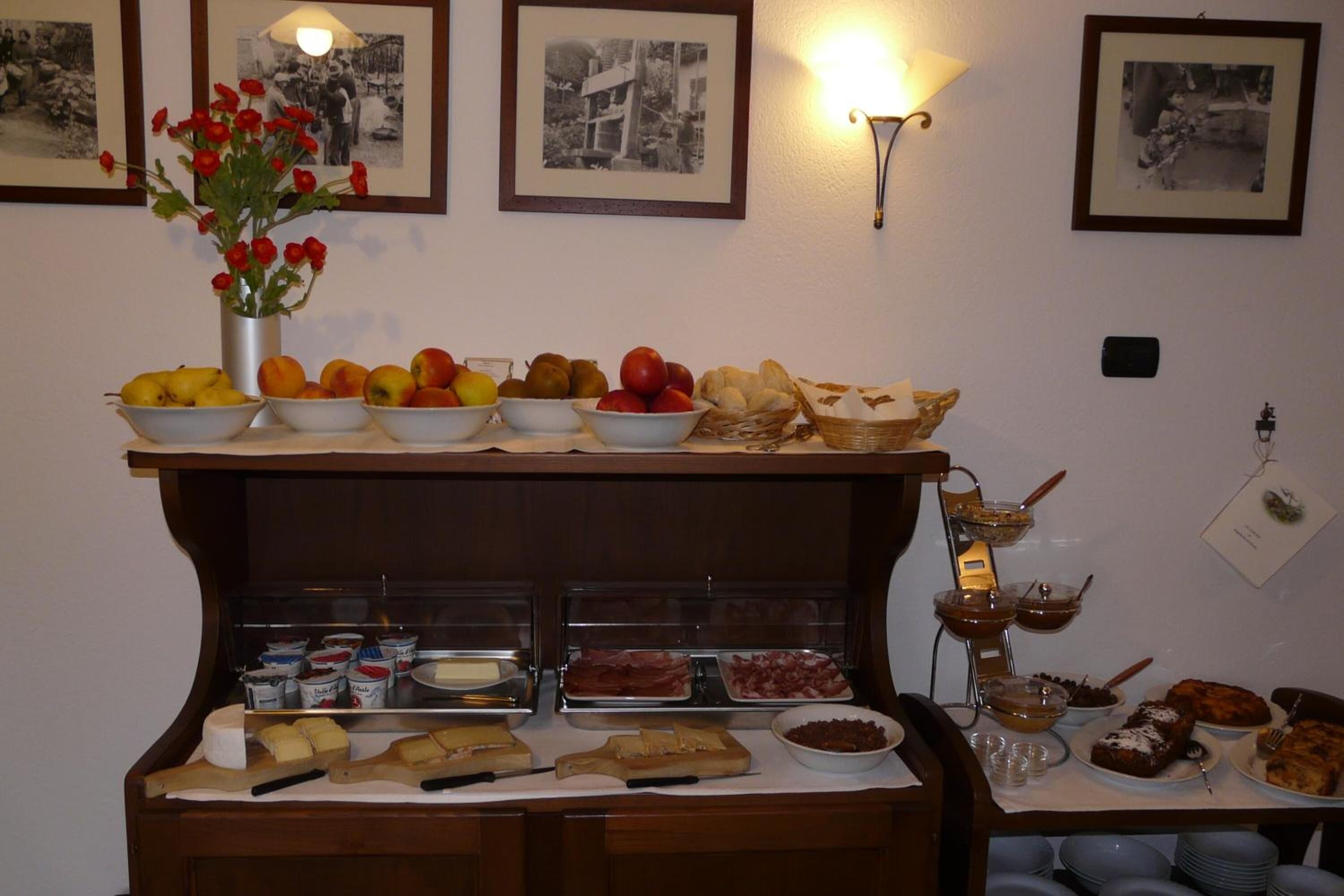 A buffet with various food items and a vase of flowers.