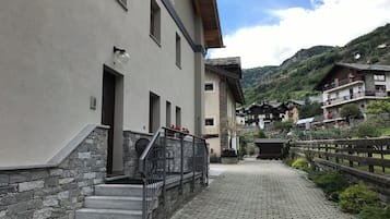 Una calle empedrada que conduce a un edificio con una escalera de piedra y una barandilla metálica.