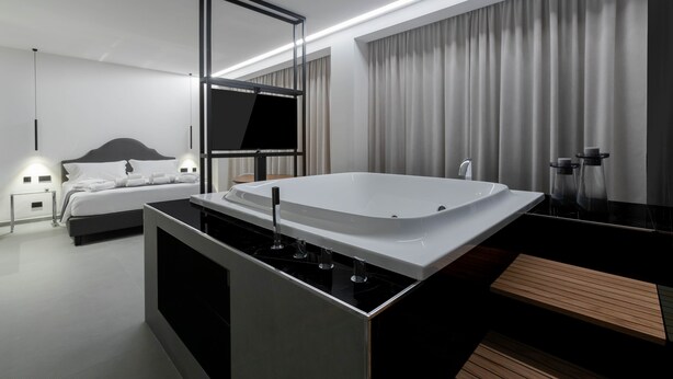 A modern bathroom with a large bathtub, a separate shower area, and a vanity with a mirror. - Suite Palermo Apartment (Palermo)