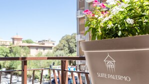 A balcony with a potted plant labeled "Suite Palermo" and a view of a cityscape. - Suite Palermo Apartment (Palermo)