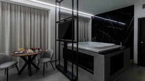 A modern bathroom with a large bathtub, a separate shower area, and a dining table with chairs. - Suite Palermo Apartment (Palermo)