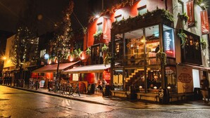 Un edificio con un bar llamado Bar Rua, que cuenta con terraza y una escalera que lleva a un nivel superior.