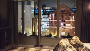 Una habitación con un ventanal grande que da a un paisaje urbano nocturno.