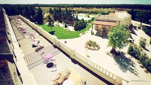 A rooftop deck with outdoor seating and a pool. - Le Scuderie - Castello Monaci (Salice Salentino)