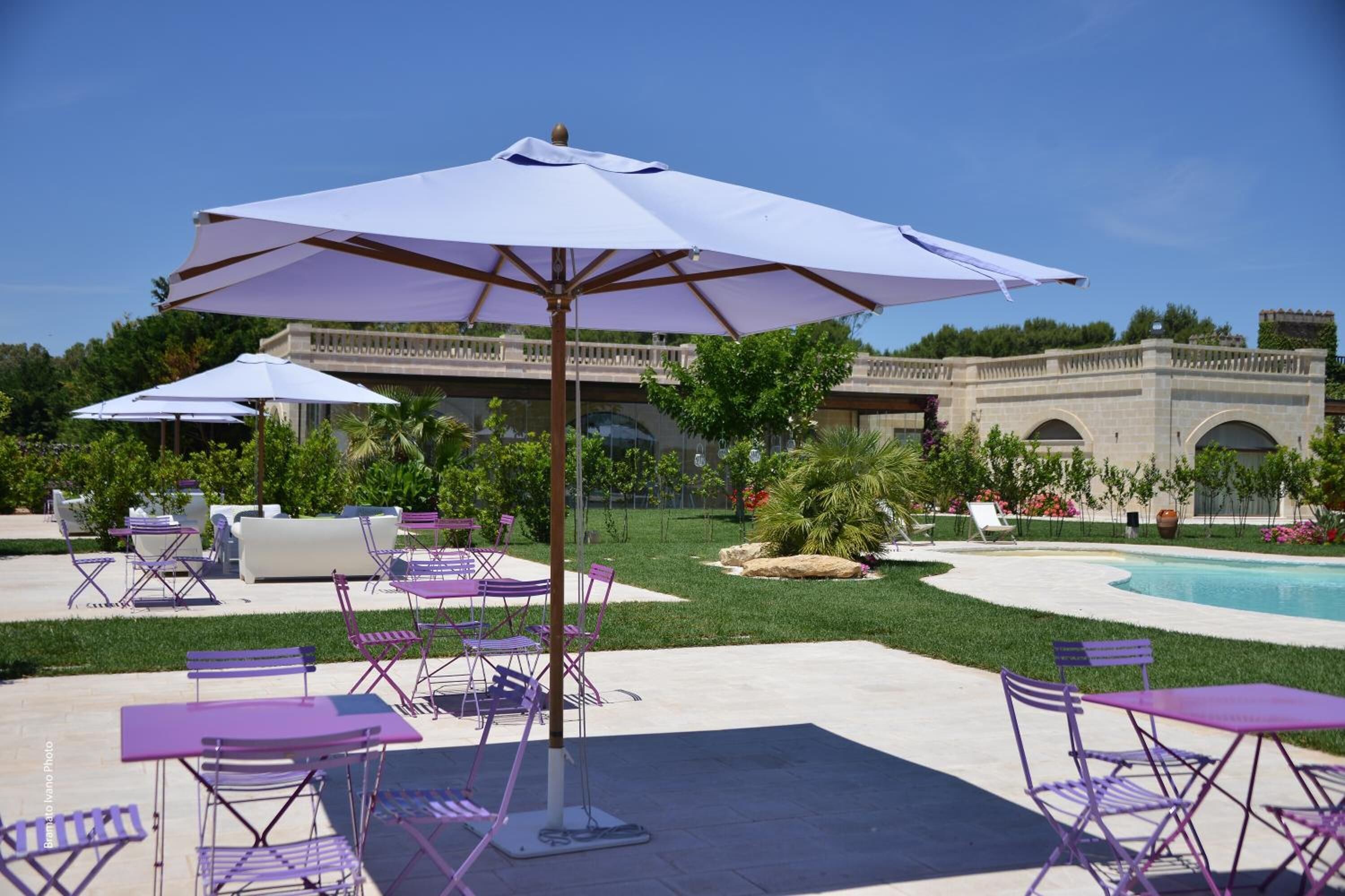 A poolside area with outdoor seating and umbrellas.
