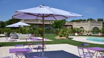 A poolside area with outdoor seating and umbrellas.