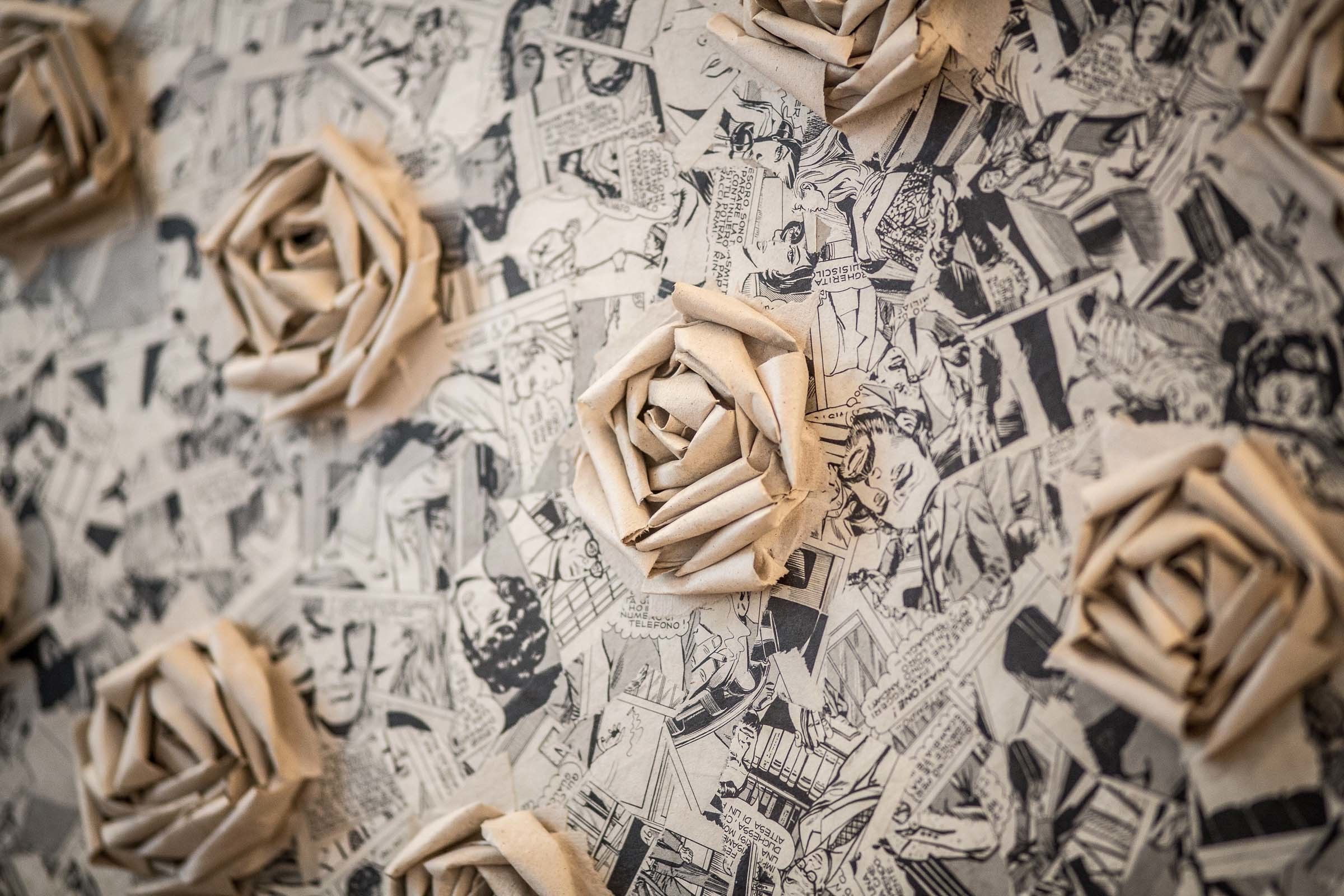 Un mur décoré de roses en origami et de motifs inspirés des bandes dessinées.