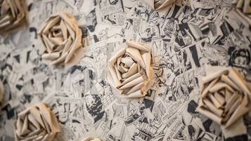 Un mur décoré de roses en origami et de motifs inspirés des bandes dessinées.