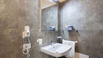 Een badkamer met een witte wastafel, een spiegel en een handdoekhouder.