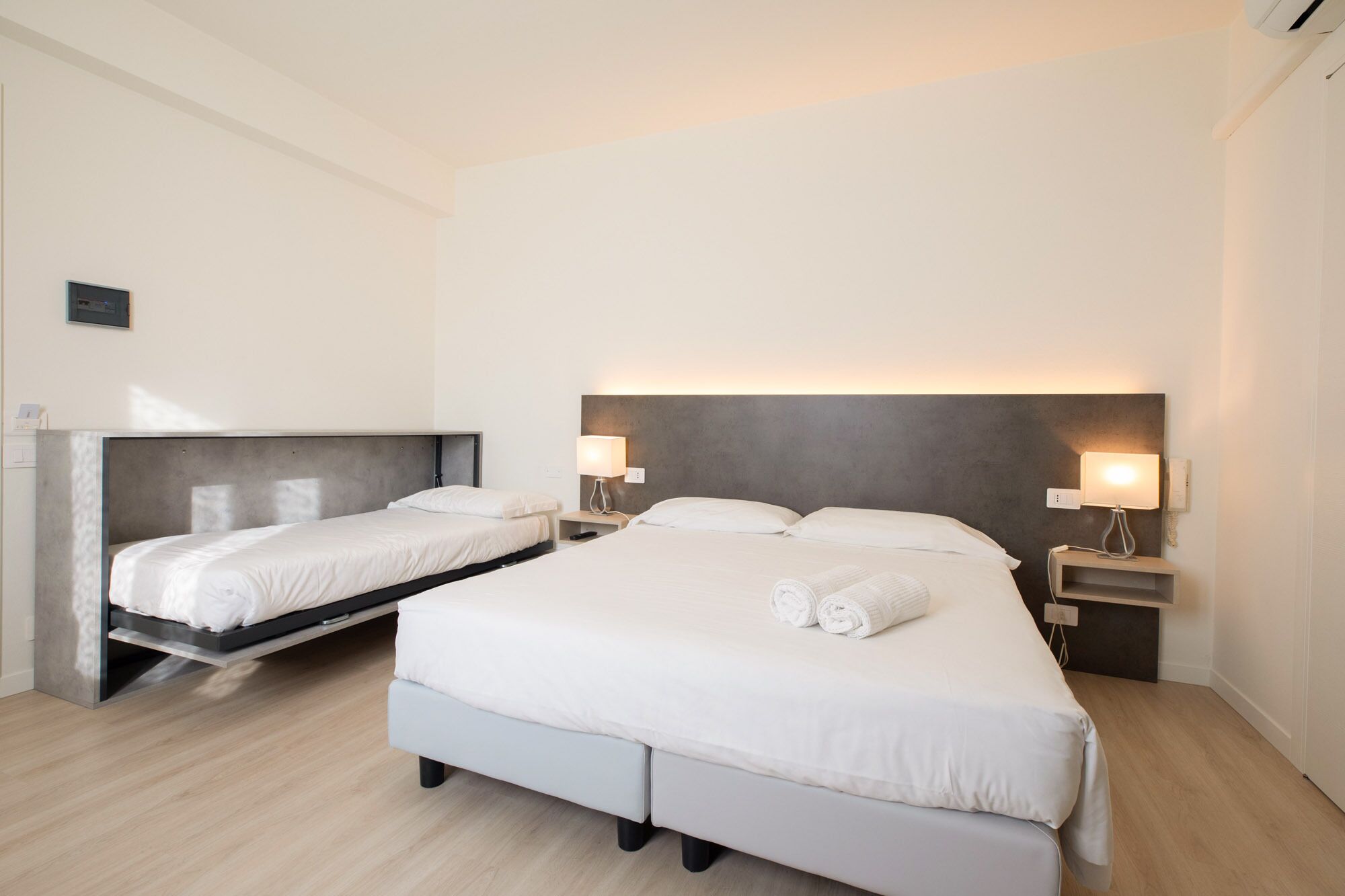 Une chambre d’hôtel avec deux lits, chacun étant équipé d’une table de chevet et d’une lampe.