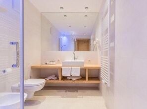 A modern bathroom with a toilet, sink, and mirror. - Anewandter Historic Hotel (Gais)