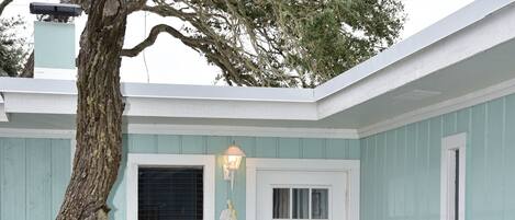 A house with a white door, a window, and a welcome sign.