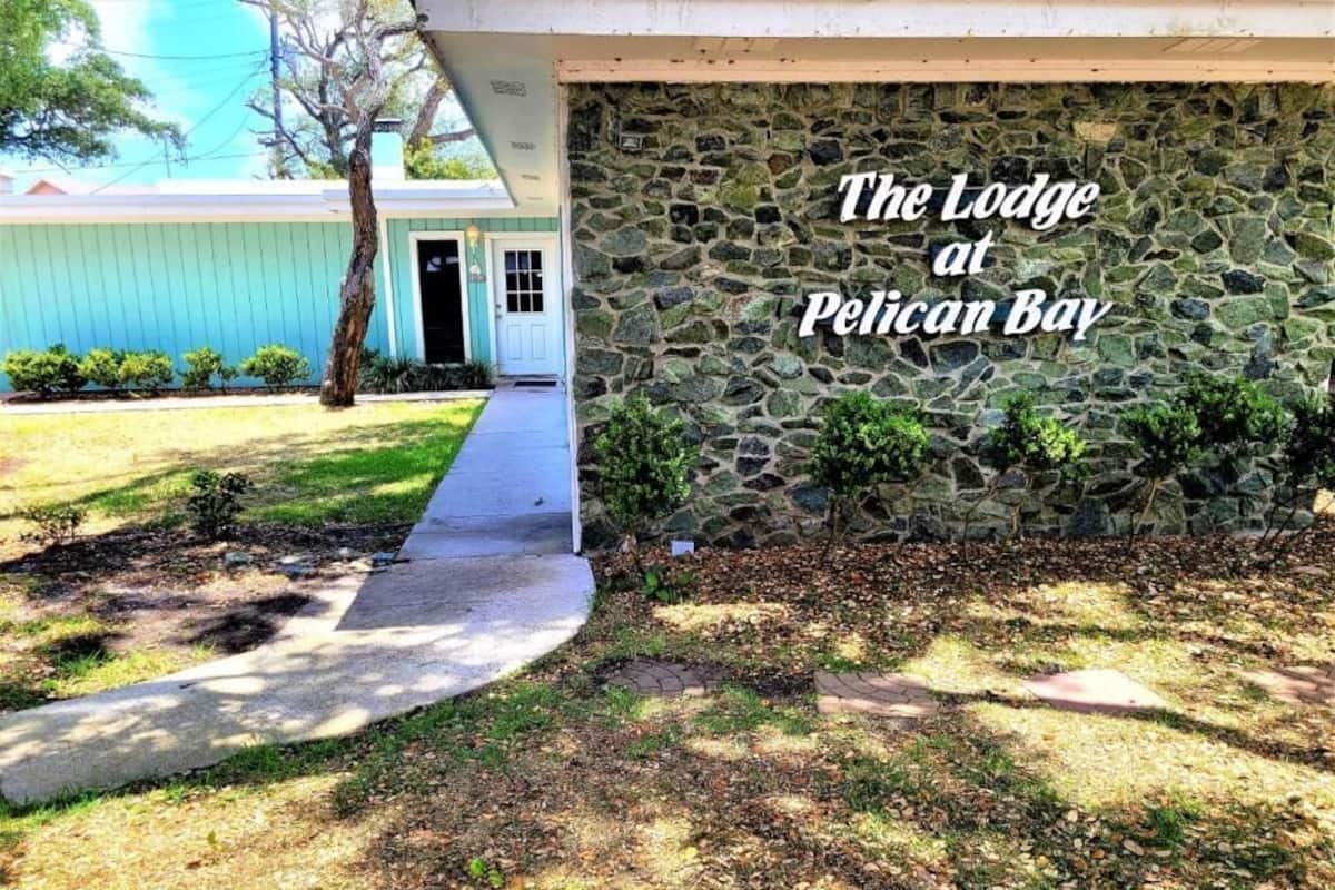 Un edificio de piedra con un letrero que dice "The Lodge at Pelican Bay".