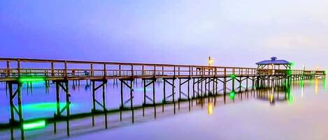 Un muelle que se adentra en aguas tranquilas con una pequeña construcción al final.