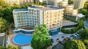 A multi-story hotel with a swimming pool, parking area, and lush greenery. - Elena Hotel - All Inclusive (Golden Sands)