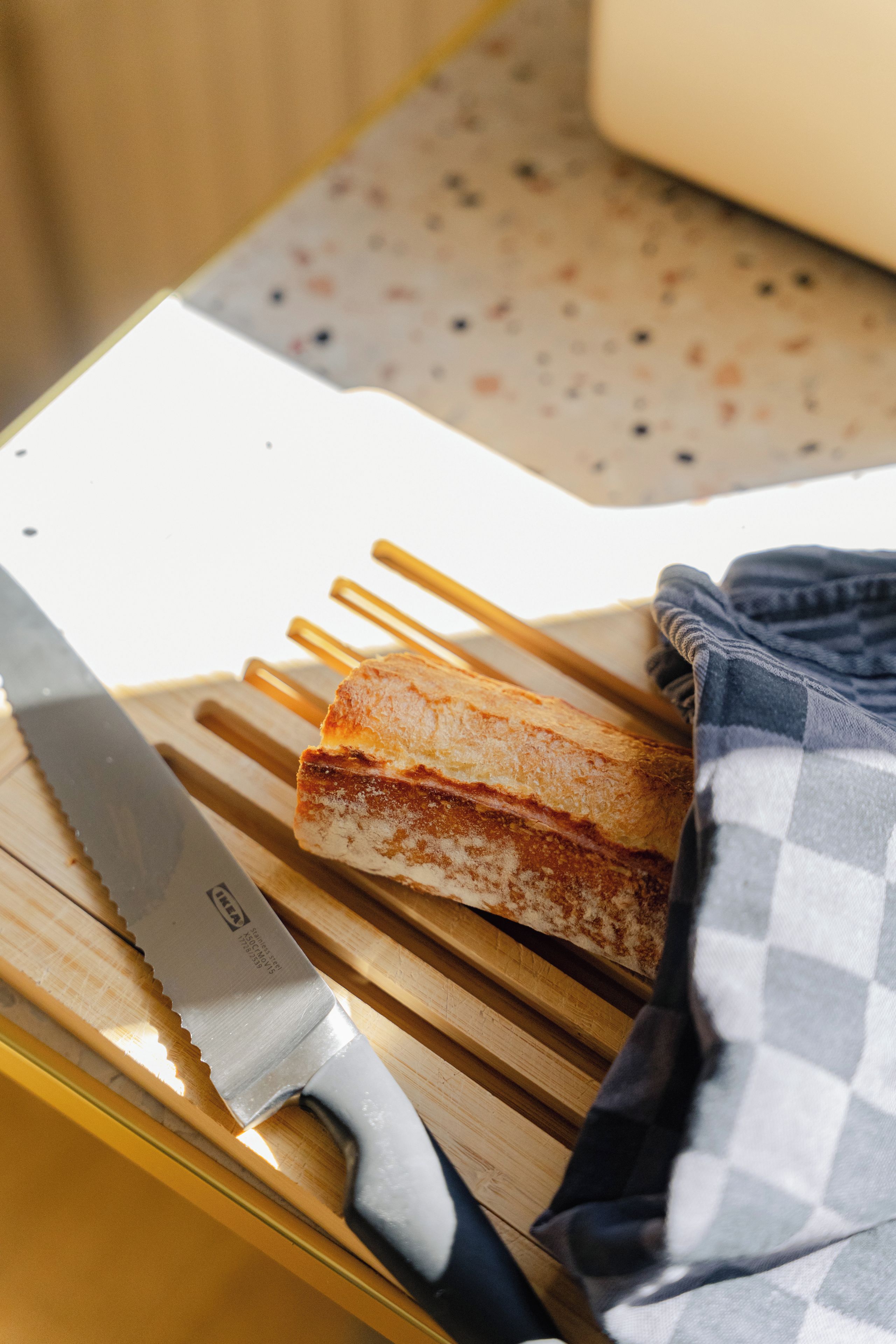 Un sandwich sur une planche à découper en bois, avec un couteau à côté.