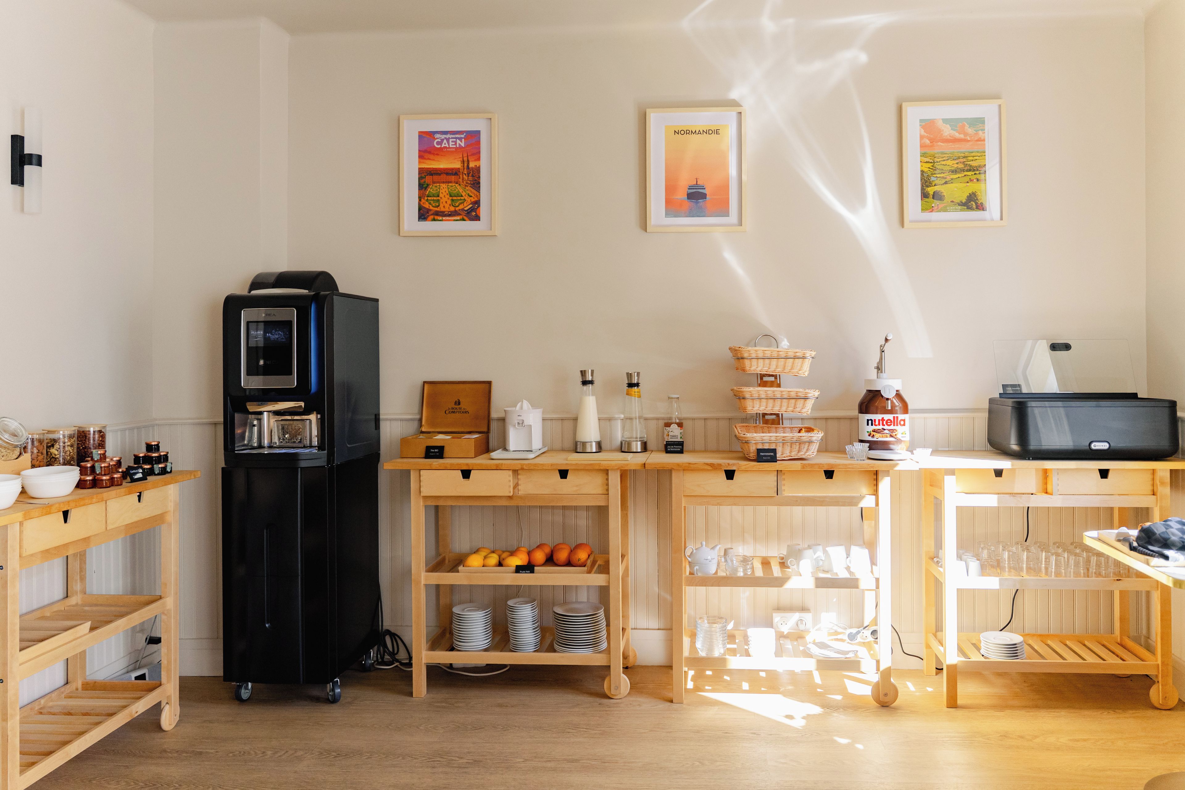 Un área de cocina con cafetera, refrigerador y estantes con utensilios de cocina.