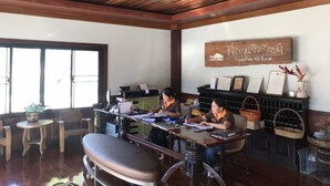 A rustic interior with wooden ceiling beams, a reception desk, and a wine rack. - Chiang Khan Hill Resort (Chiang Khan)