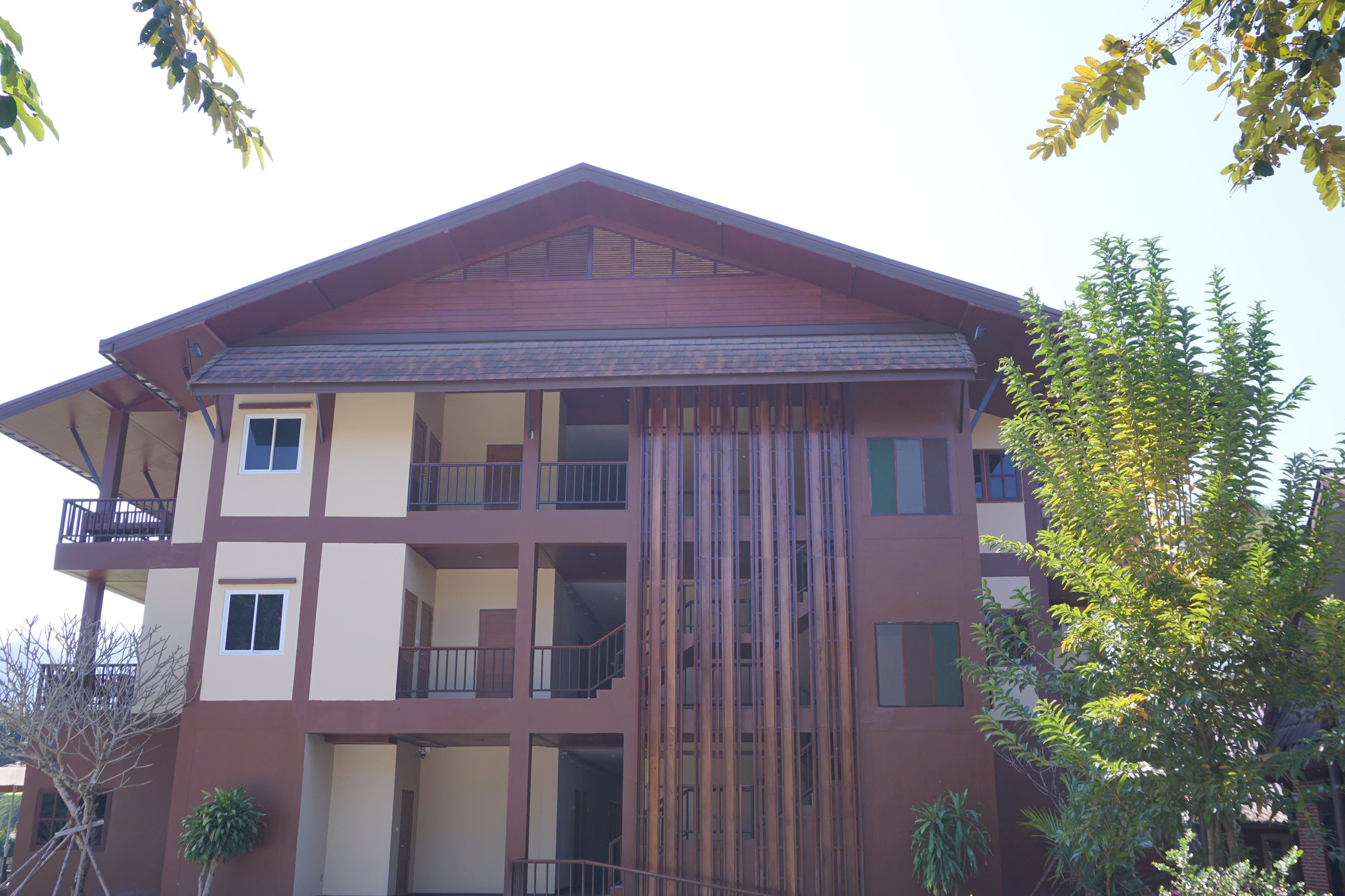 A multi-story building with balconies and a central staircase.