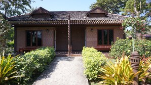 A brick house with a tiled roof, a front porch, and a pathway leading to the entrance. - Chiang Khan Hill Resort (Chiang Khan)
