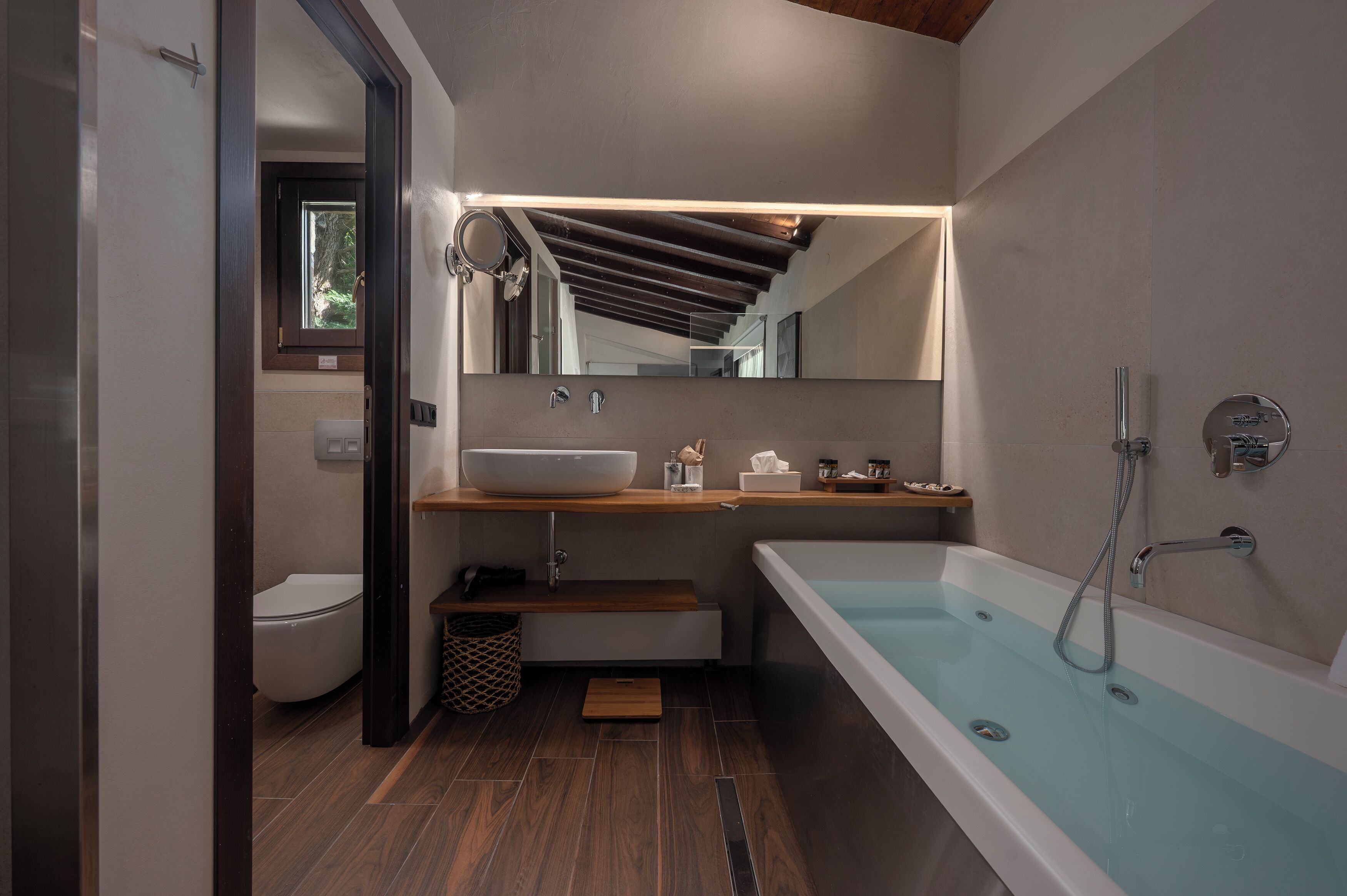 Un baño moderno con una bañera independiente, un inodoro y un tocador con espejo.