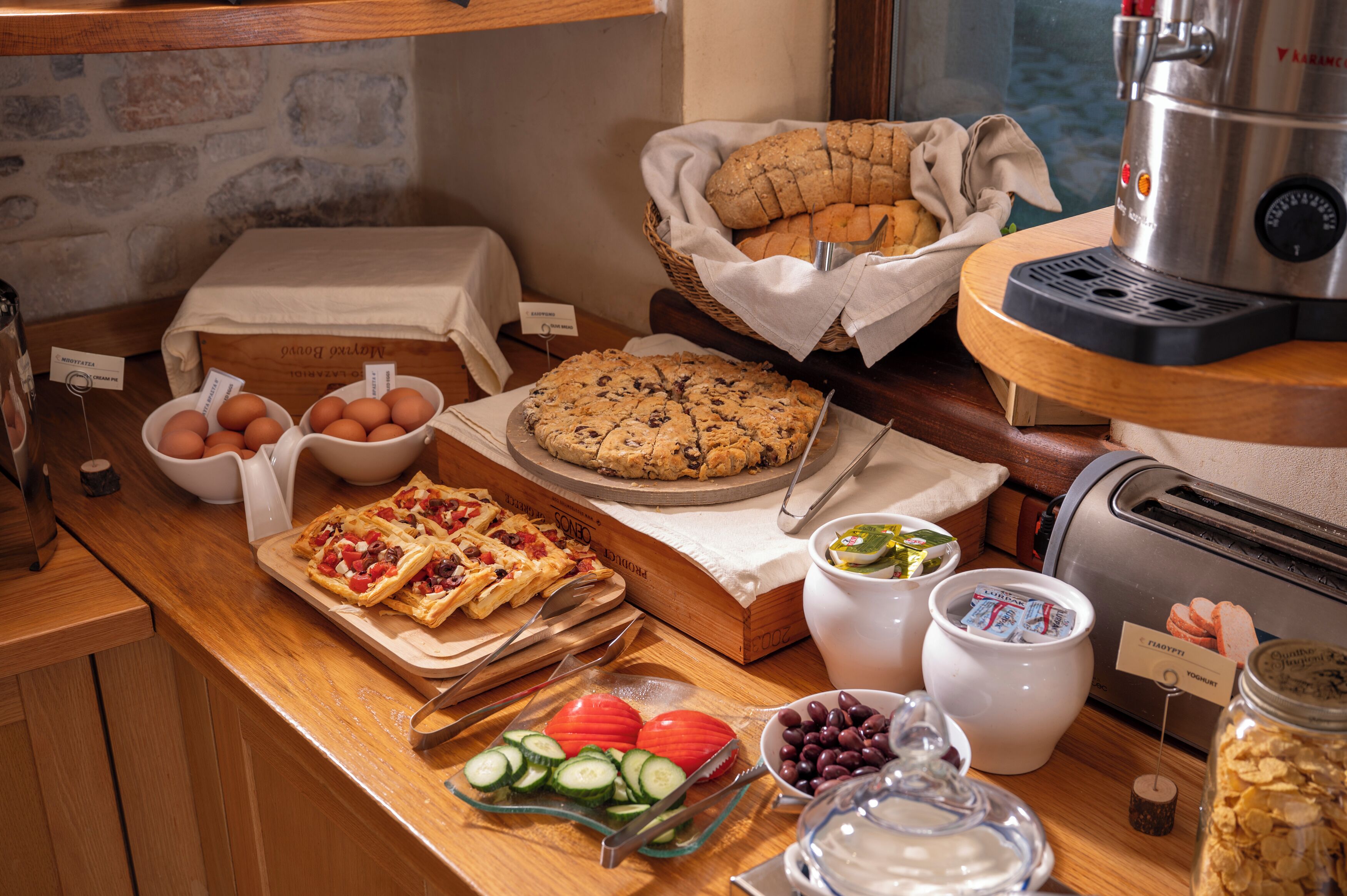 Ein Frühstücksbuffet mit verschiedenen Speisen, darunter Eier, Brot und Pizza.