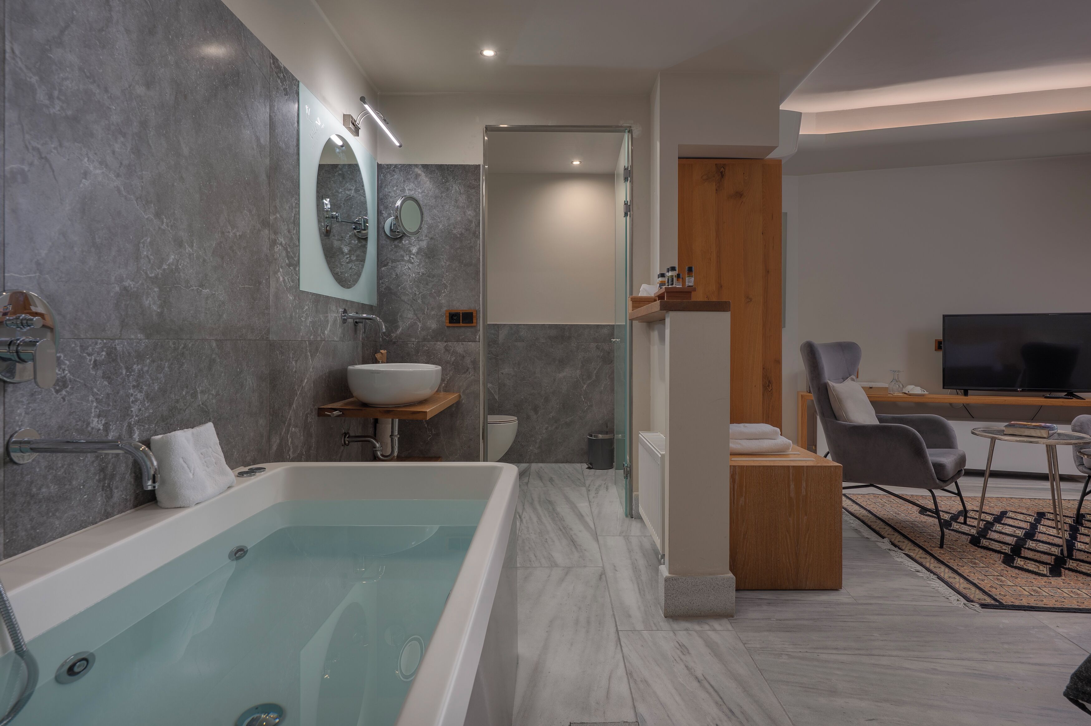 Een moderne badkamer met een bad, een wastafel met spiegel en een douchehoek.