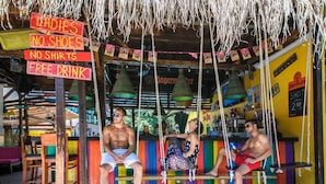 A bar area with colorful seating and signs indicating 'Ladies No Shoes, No Shirts, Free Drink'. - Mimosa Sunshine Hotel COOEE - All Inclusive (Golden Sands)