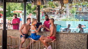 A poolside bar area with tiled walls and a tiled pool in the background. - Mimosa Sunshine Hotel COOEE - All Inclusive (Golden Sands)