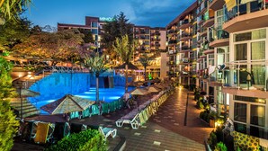 A hotel with a swimming pool, outdoor seating, and multiple balconies. - Mimosa Sunshine Hotel COOEE - All Inclusive (Golden Sands)