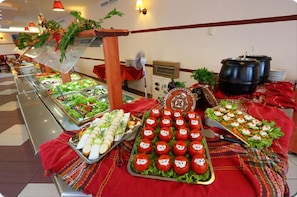 A buffet setup with various food items, including salads, sandwiches, and decorated tomatoes. - Ambassador Hotel (Golden Sands)