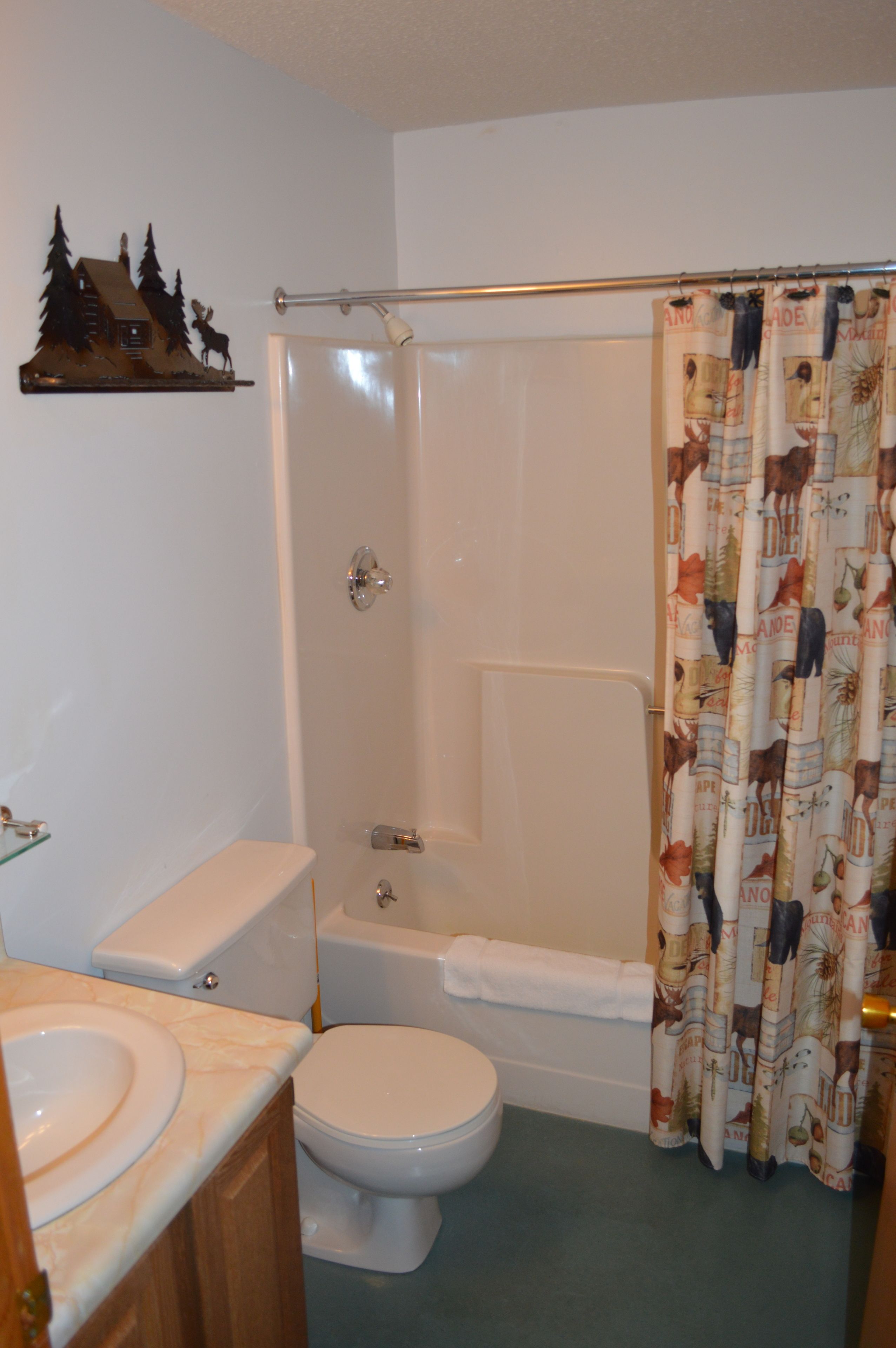 A bathroom with a shower, toilet, and sink.