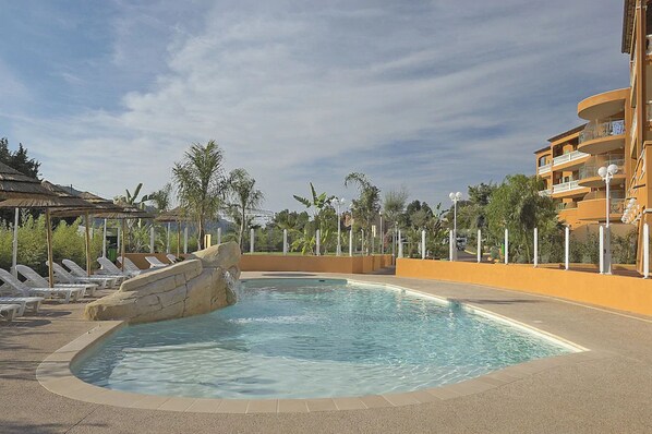 Alberca al aire libre y camastros 