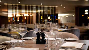 A restaurant setting with tables set for dining, featuring clear glassware and cutlery.