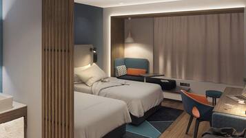 A hotel room with two beds, a desk with a chair, a lamp, and a window with curtains.
