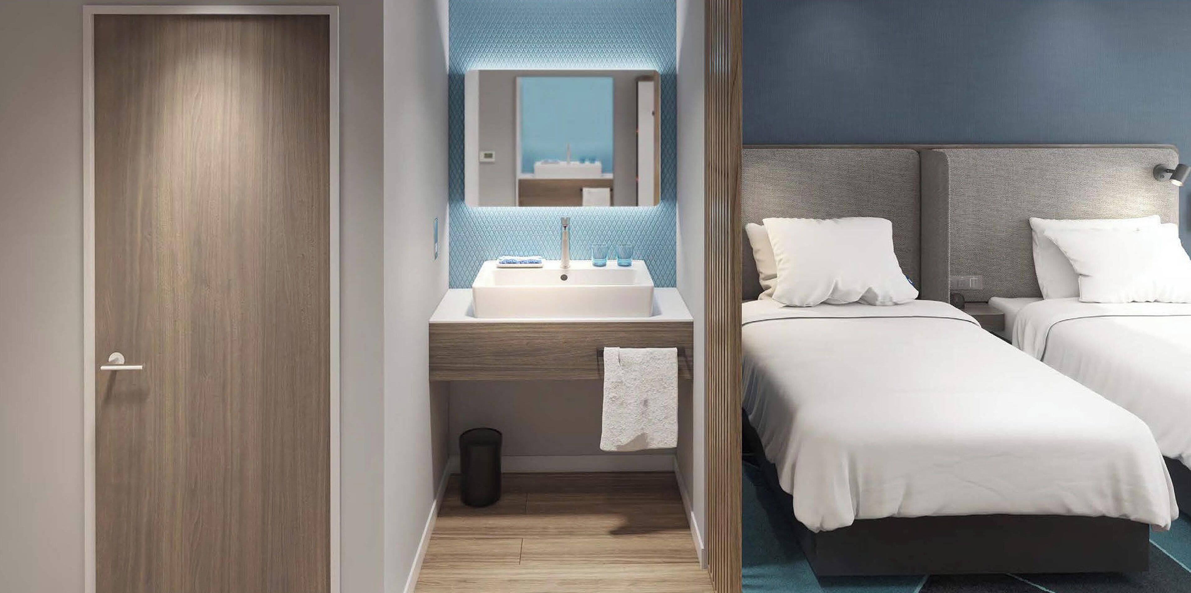 A hotel room with a wooden door, a bathroom with a sink and mirror, and two beds with white bedding.