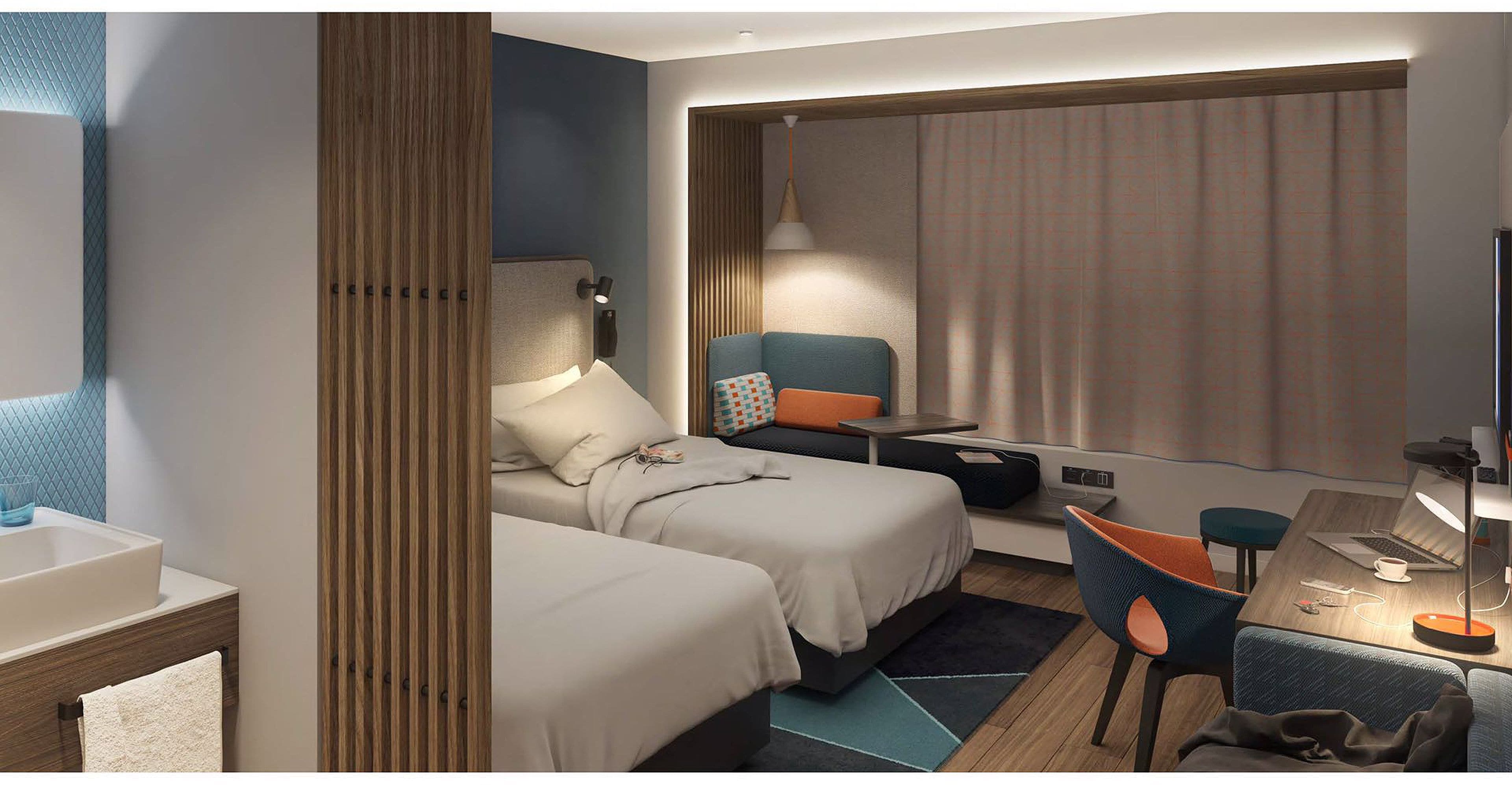 Ett modernt hotellrum med två sängar, ett skrivbord, en stol och ett stort fönster med gardiner.