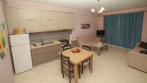 A compact living space with a kitchenette, dining area, and seating. - Serxhio Apartments (Sarandë)