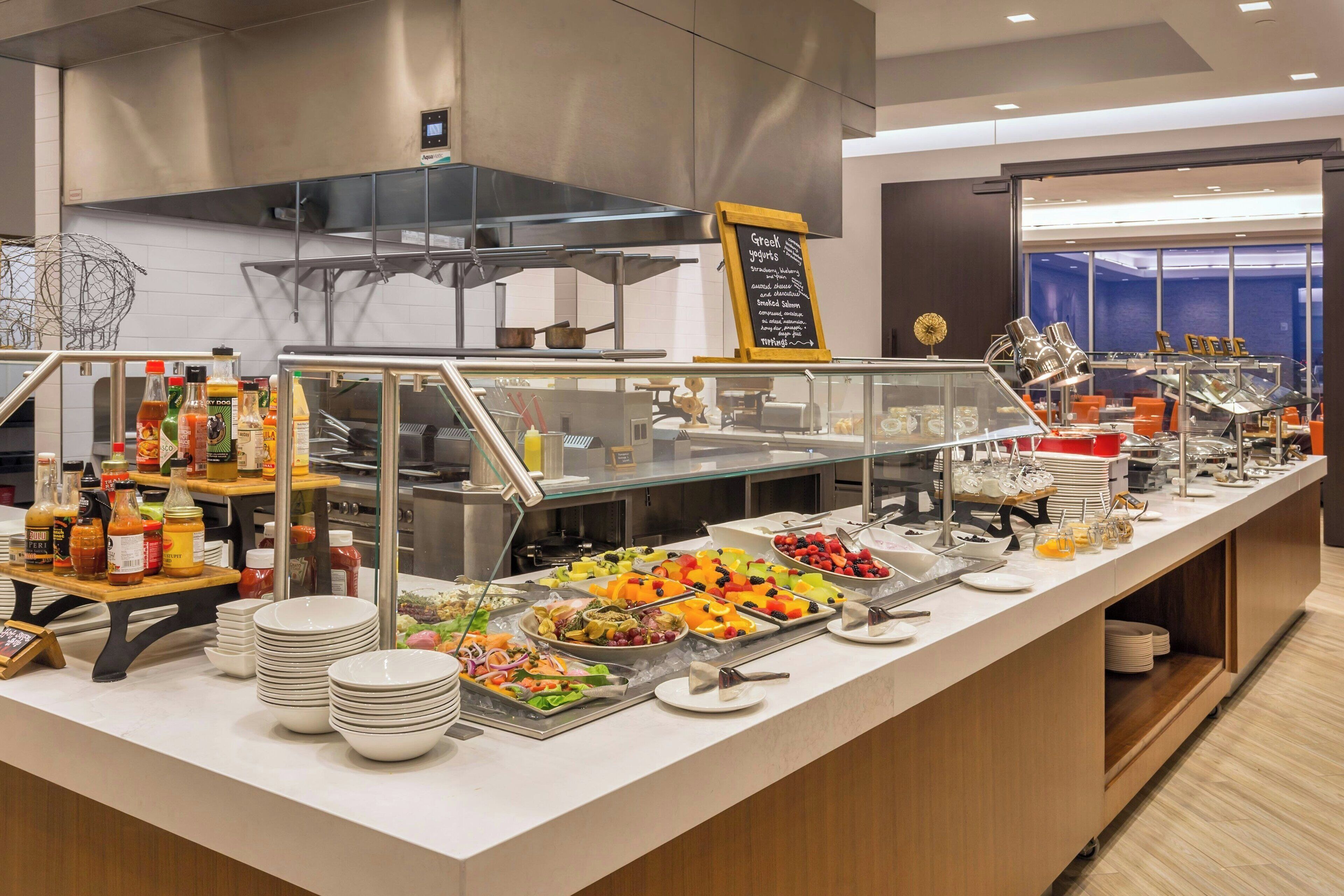 A buffet area with various food items and condiments.