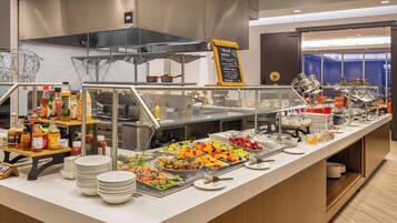 A buffet area with various food items and condiments.