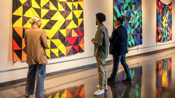 A gallery with large geometric artworks on the walls.