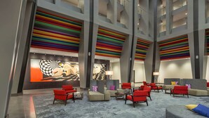 A spacious lobby with high ceilings, modern seating, and vibrant artwork. - The Summit Hotel (Cincinnati)