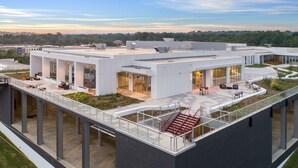 A modern building with a flat roof, large windows, and a covered outdoor area with seating. - The Summit Hotel (Cincinnati)