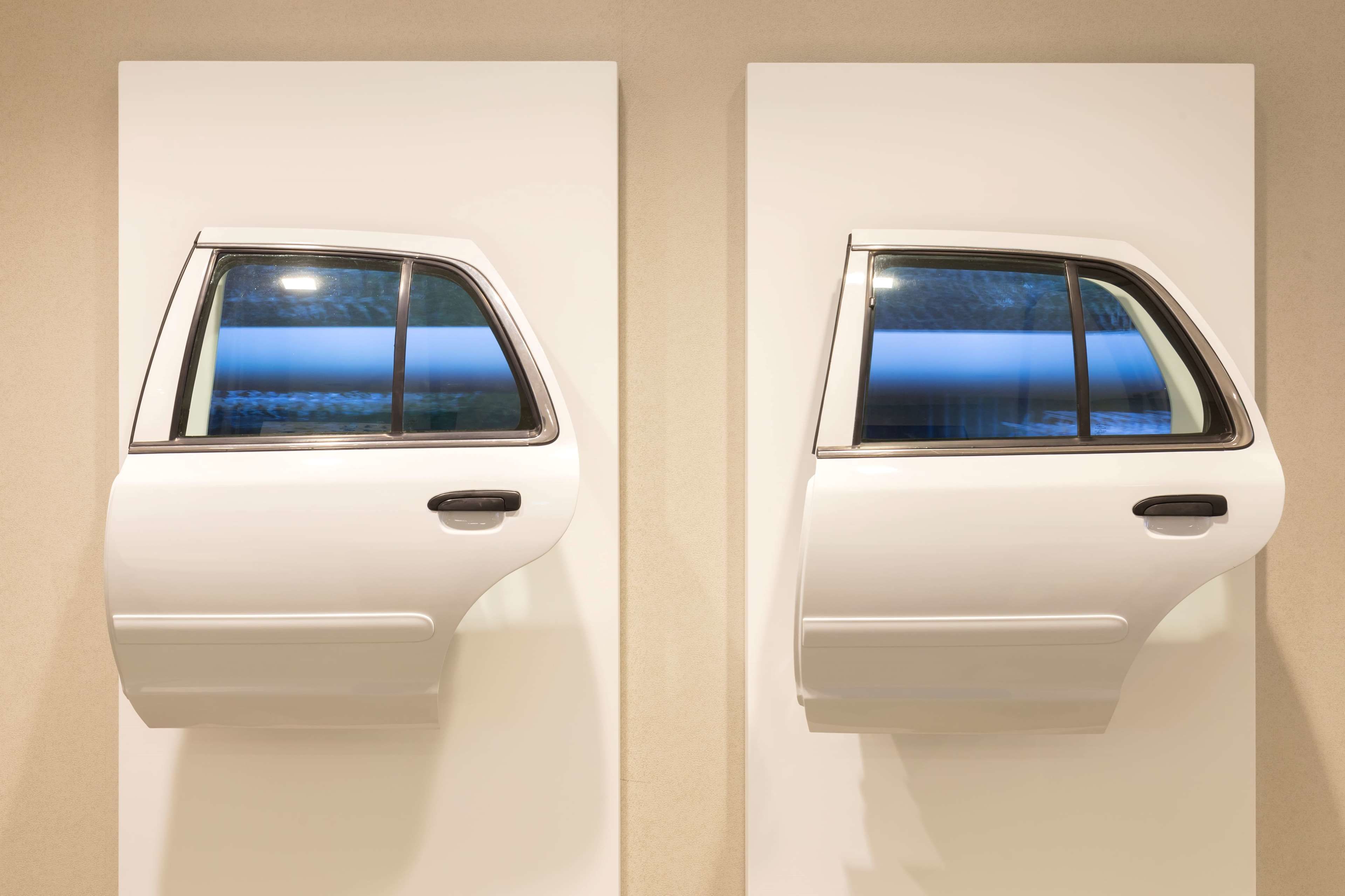 Dos puertas de coche blancas fijadas a una pared.