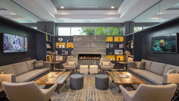 A modern living room with a fireplace, sofas, armchairs, and a coffee table. - The Summit Hotel (Cincinnati)