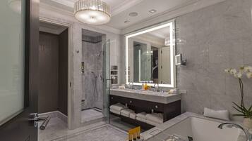 A modern bathroom with a large mirror, a bathtub, and a shower area.