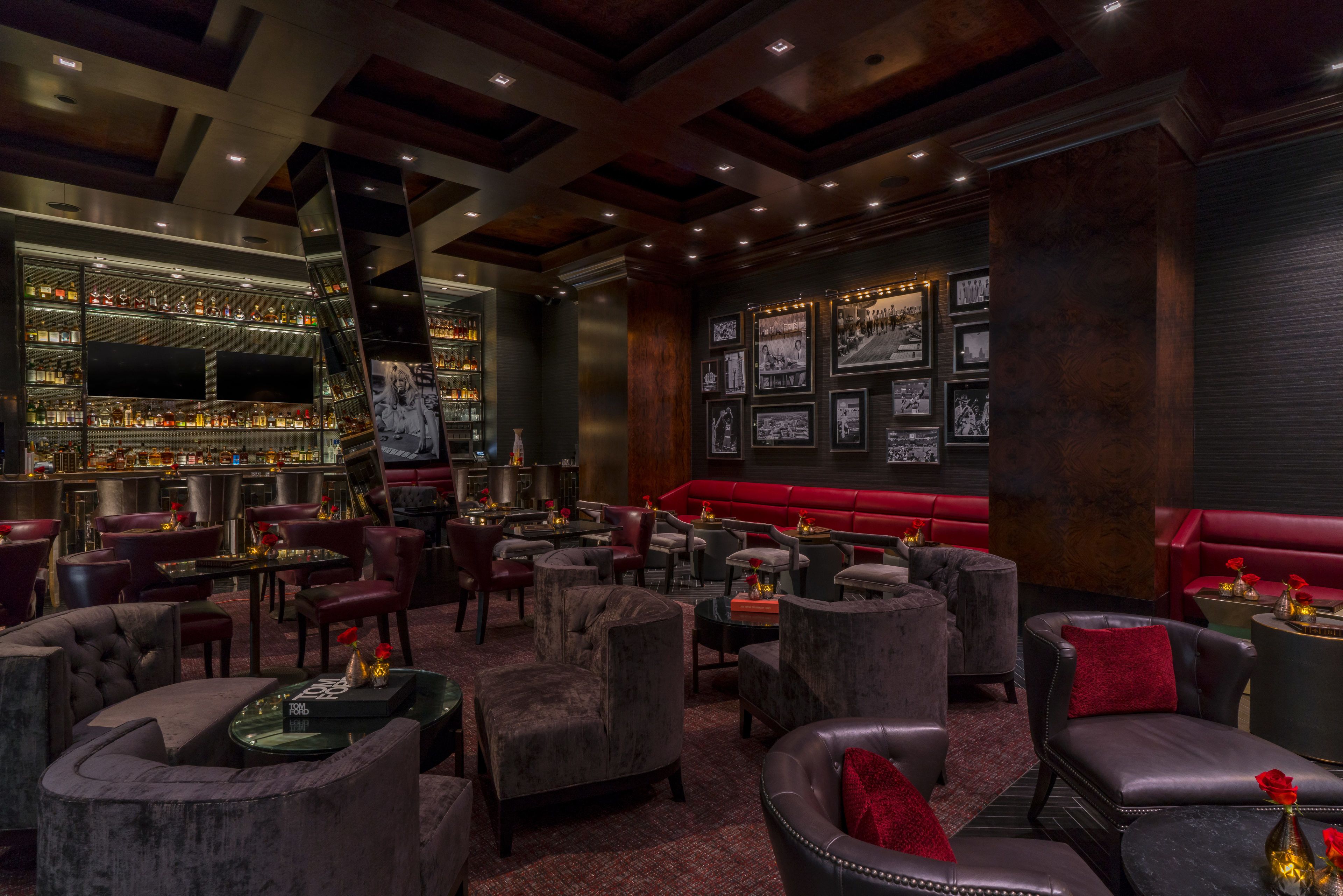 A bar area with multiple seating options, a bar counter, and framed pictures on the wall.