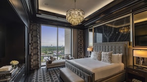 A luxurious hotel room with a large bed, a seating area, a view of the city, and a chandelier. - The Post Oak Hotel at Uptown Houston (Houston)