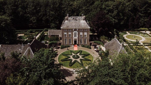 A large, historic building with a symmetrical facade, a central courtyard with a star-shaped lawn, and surrounding formal gardens. - Châteauhotel en restaurant De Havixhorst (De Schiphorst)