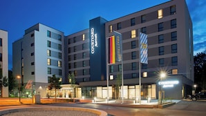 Un hotel Courtyard Marriott con un diseño moderno, con varios pisos y una entrada destacada con señalización iluminada.